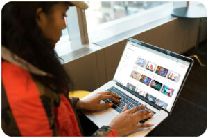 Femme sur son ordinateur portable regardant le catalogue de cours en ligne talenteed avec une vue sur la ville